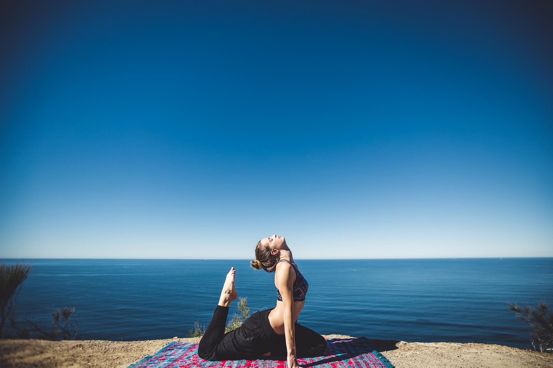 Chica hace yoga en el mar